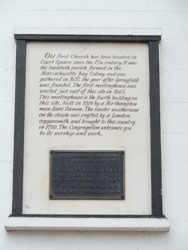 Plaque auf einer Gebäudewand mit der Aufschrift "National Register of Historic Places" in fetter Schrift, innerhalb eines dekorativen Rahmens auf dunklem Material montiert.