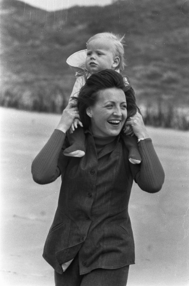 Eine Frau, die glücklich ist und ihr Baby hält, mit einem sanft unscharfen Hintergrund, der einen träumerischen Effekt erzeugt.