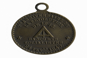 Bronze medal with the words "Banquets Socialistes" inscribed on it against a white background.