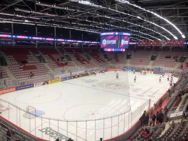 Eishockeyspiel in einer großen Arena zwischen den St. Louis Blues und Detroit Red Wings, mit Zuschauern auf den Sitzen und um das Eis herumstehend.