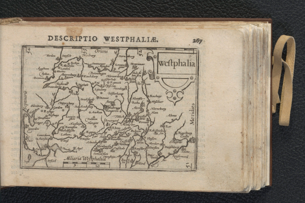 Ein aufgeschlagenes Buch mit einer detaillierten Karte der geographischen Merkmale Westfalens auf einem schwarzen Untergrund.