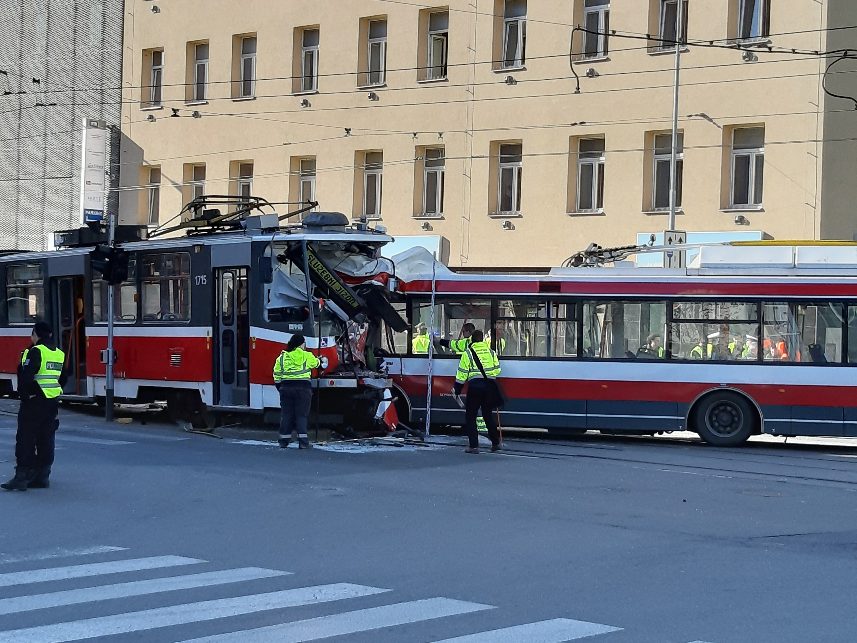 Rote und weiße Straßenbahn beteiligt an einem Straßenrand-Crash mit einigen Menschen in der Nähe und einem Gebäude im Hintergrund.