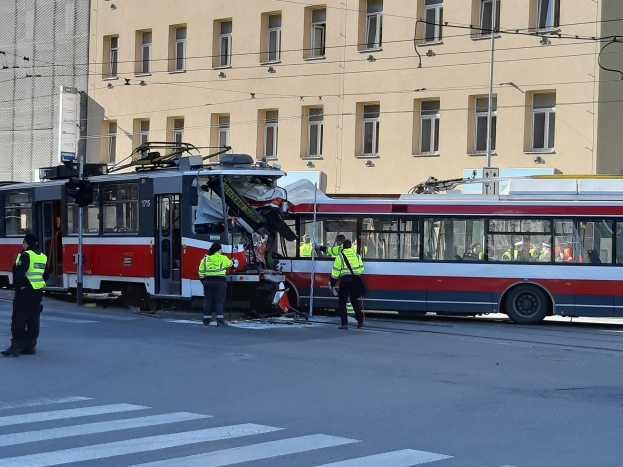 Rote und weiße Straßenbahn beteiligt an einem Straßenrand-Crash mit einigen Menschen in der Nähe und einem Gebäude im Hintergrund.