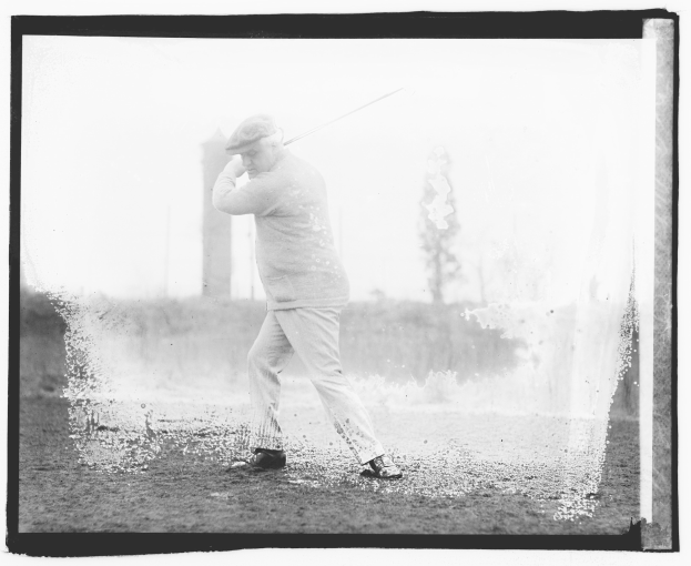Schwarz-weiß-Foto eines Mannes, der einen Golfschläger auf einem grasbewachsenen Gebiet schwingt.